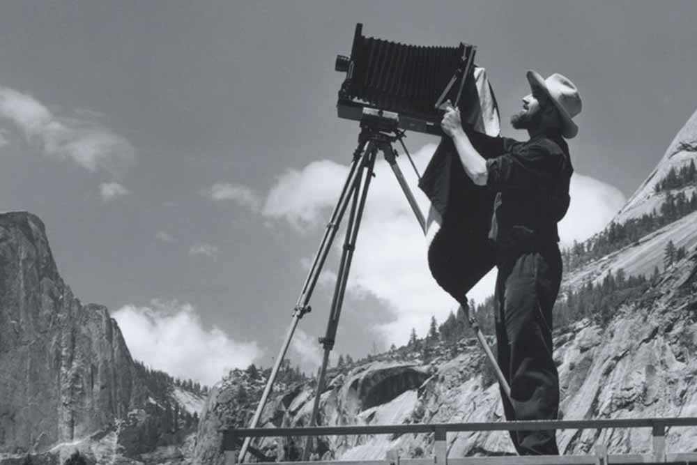 Ansel Adams using camera on a tripod