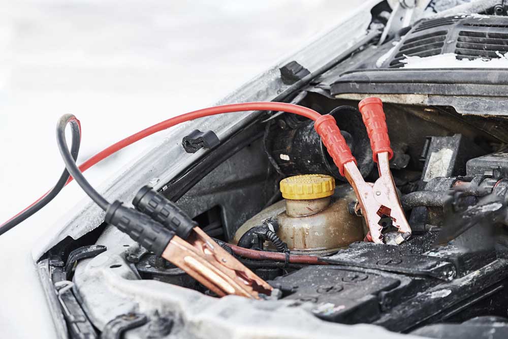 Car battery with jump cables in cold weather