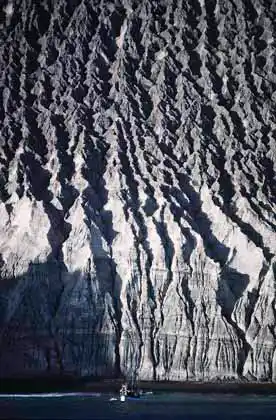 Yacht anchored below flow marks on cinder cone.
